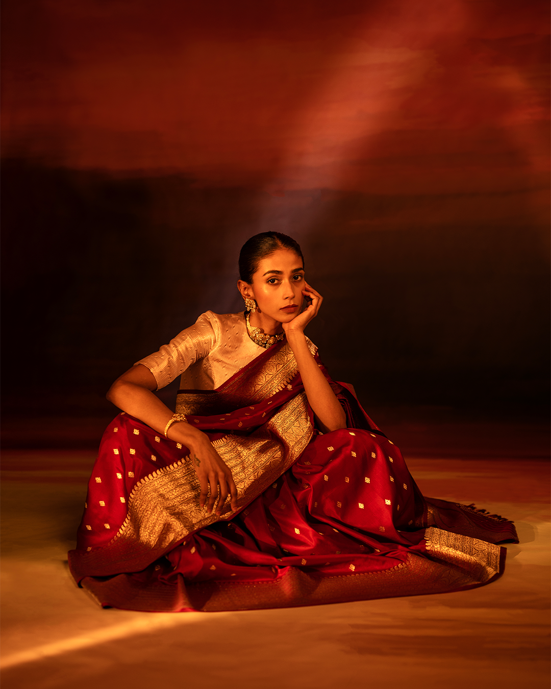 Kathak dancer sitting gracefully on the floor and performing. - SuperStock